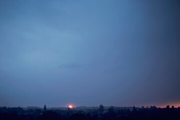 Sunset over the city. Silhouette of the city against the sky. Colorful landscape.