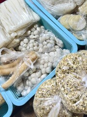 Assorted Indonesian Market Ingredients: Rice Cakes, Fish Balls, Tempeh, and Bean Sprouts in Plastic Packaging