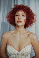 Portraits of an attractive girl with curly hair and slim figure in the studio