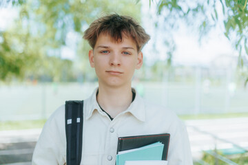 Tired Student Standing by the Fence in the Schoolyard