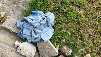 Rumbled denim whispers untold tales, nestled among cobblestones, Earth Day cleanup inspiration...