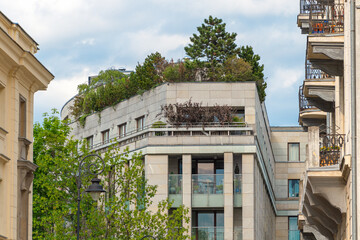 Fototapeta premium Urban residential building with green rooftop garden and balconies