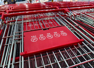 A row of shopping carts is neatly lined up in a straight row