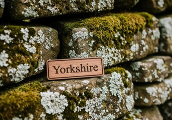 Wooden Yorkshire sign on moss-covered stone wall celebrating Yorkshire Day