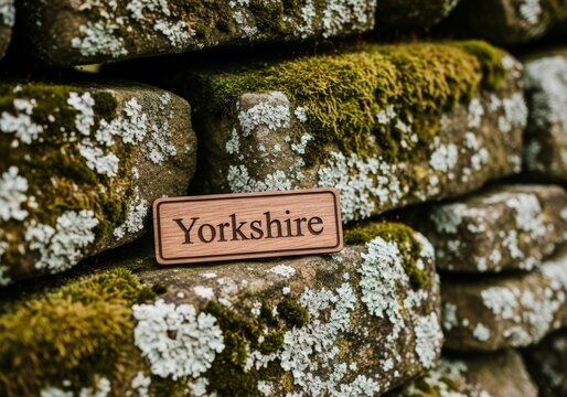 Wooden Yorkshire sign on moss-covered stone wall celebrating Yorkshire Day - Powered by Adobe