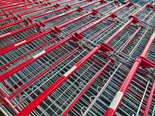 A row of shopping carts is neatly lined up in a straight row