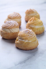 Kue Sus Isi Vla or soes cake (Choux Pastry Cream Puff) is Crispy and airy choux pastry shell are filled with smooth and soft custard cream. 