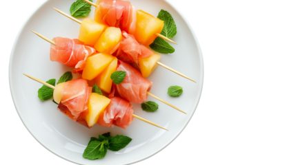 Melon and prosciutto skewers with mint on white plate, top-down angle