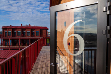 Number 6 on the glass door of an apartment building, sunny day