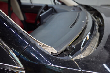 Automobile special workers remove old windscreen or windshield of a car in auto service station garage. Background
