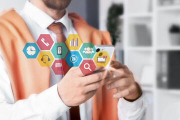 Businessman working with mobile phone in office, closeup