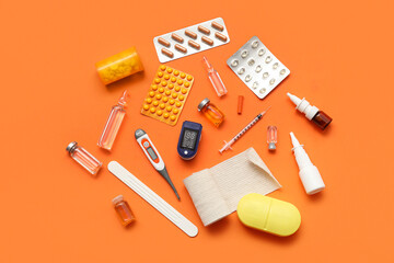 Composition with pulse oximeter, thermometer and medicines on orange background