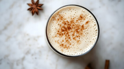 Aromatic chai latte with cinnamon and star anise on a marble surface presentation