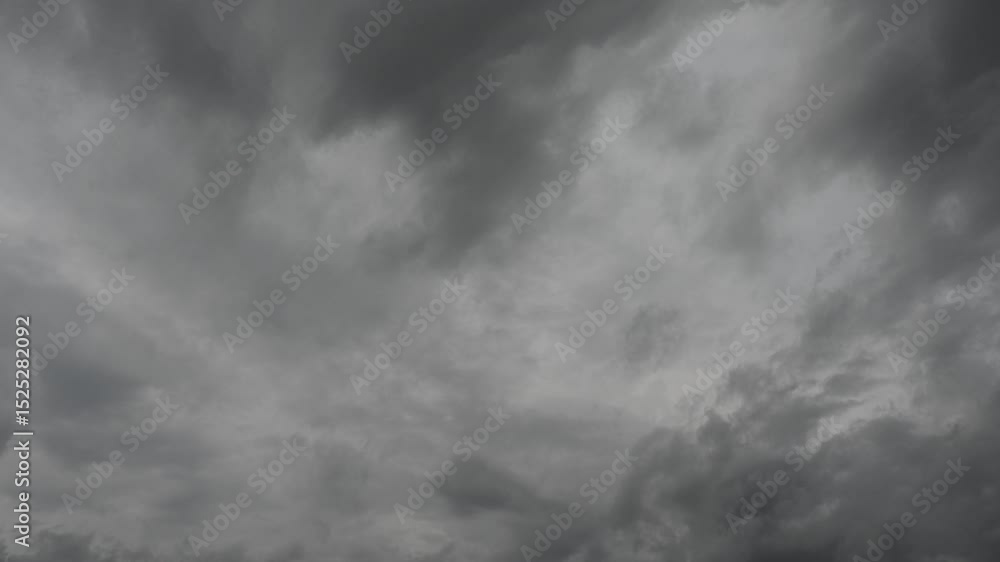 Sticker timelapse looking up at a sky filled with gray colored rain clouds as they move across the frame