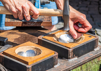 Crafting metal shapes through traditional methods at a crafting workshop in the afternoon light
