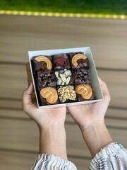close up of a man hand holding a bowl of cookies