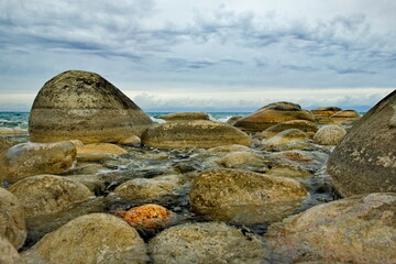 Northern Kyrgyzstan. The landscape of the cold lake Issyk-Kul with colorful round stones of...