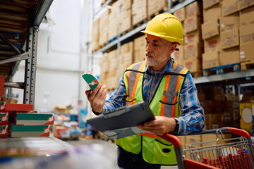 Senior foreman checking packages during quality control inspection at distribution warehouse.