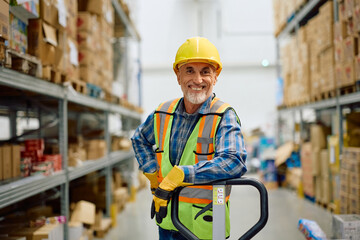 Happy senior warehouse worker in storage room looking at camera.