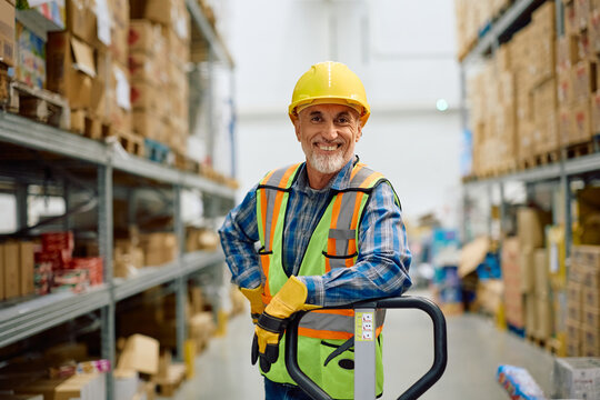Happy senior warehouse worker in storage room looking at camera. - Powered by Adobe