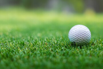 Obraz premium Golf ball on the green grass close up view