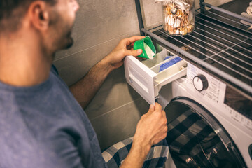Man putting Detergent In Washing Machine