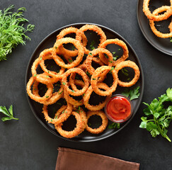 Onion rings with tomato sauce on plate