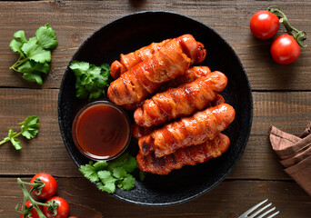 Bacon wrapped sausages with barbecue sauce