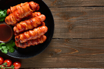 Bacon wrapped sausages with barbecue sauce