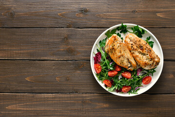 Roasted chicken breast and vegetable salad on plate