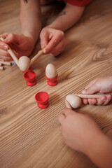 Early childhood development and parent-child bonding activities indoors.child and mother hands playing with wooden sticks on the floor.