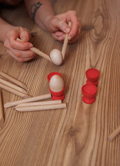 close up of woman hands playing with wooden peg. Child development concept, fine motor skills