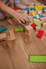 little boy playing with wooden toy blocks at home.