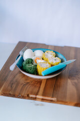 Balanced nutritious portion featuring boiled eggs, broccoli, and cut corn