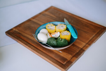 Corn, broccoli and egg on wooden board. Balanced diet concept.