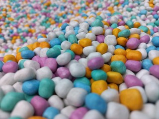 Multi-colored synthetic sand with a blurred background, suitable for creative and sensory themes