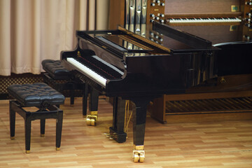 Elegant black grand piano with leather bench in a traditional music hall, accompanied by a vintage...