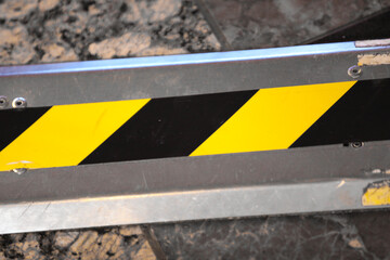 metal background with black and yellow warning stripes