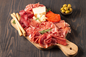 Charcuterie board. Antipasti appetizers of meat platter with salami, prosciutto crudo or jamon and olives.