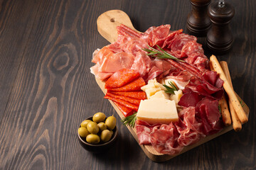 Charcuterie board. Antipasti appetizers of meat platter with salami, prosciutto crudo or jamon and olives.