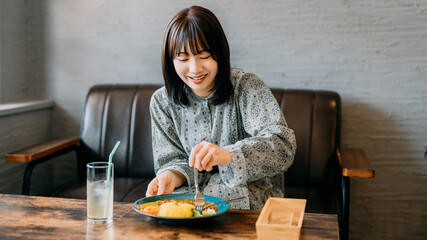 カフェで食事をする若い女性