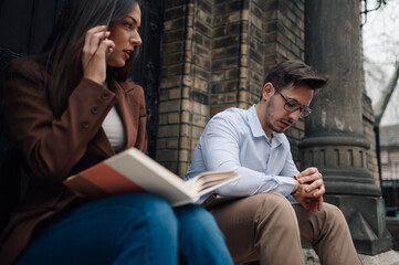 Businesspeople waiting outside, checking time and making a phone call