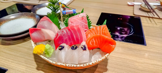 Sashimi, raw fish and seafood, tuna, salmon, squid, otoro (fatty belly of tuna), sea bass, chilled in ice bowl with wasabi in luxury restaurant