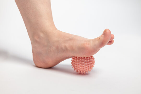Woman is training with foot massage ball from muscle pain and stress. Relaxation massage after hard work day. 