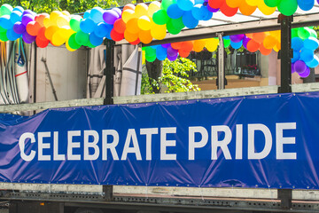 Truck with rainbow coloured balloons and with the writing on the banner Celebrate Pride, during a LGBT+ pride parade
