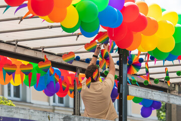  Setting up rainbow coloured balloons, paper hearts and little flags on a truck during a LGBT+ pride parade