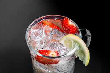 Top of a glass with a refreshing cocktail of pitahaya pieces and strawberries with lemon.