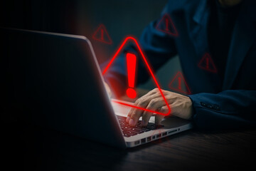 A person typing on a laptop with red warning signs and exclamation marks, symbolizing cyber threats, data breach, online danger, and digital security risks.