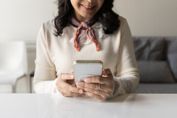 Closeup hands of happy smiling young woman using smartphone to social media online at home. Young...