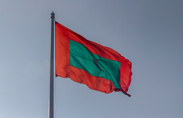 Red and green flag proudly flies under a blue sky
